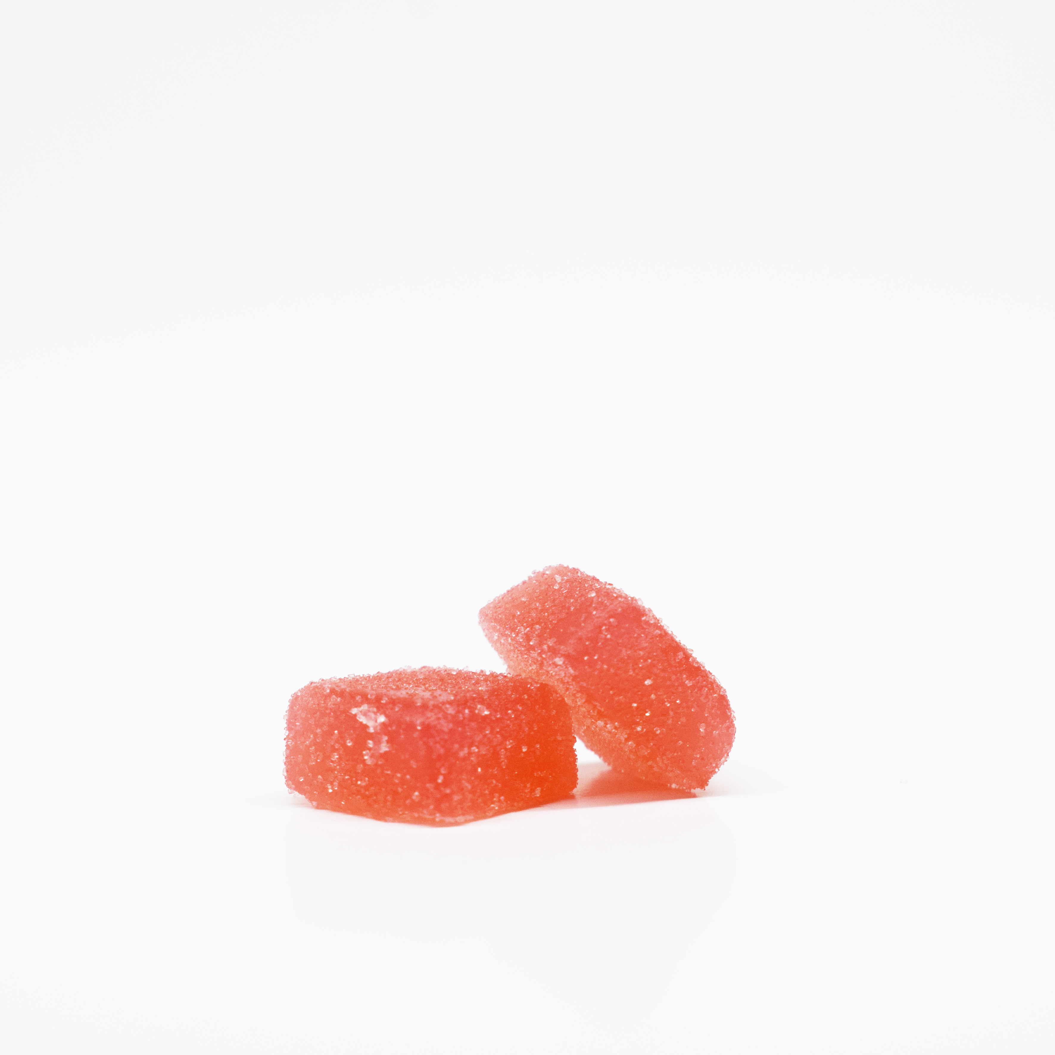 JOLLY 1:25 THC:CBD Fuji Apple Gummies. Light pink, square, sugar coated gummies